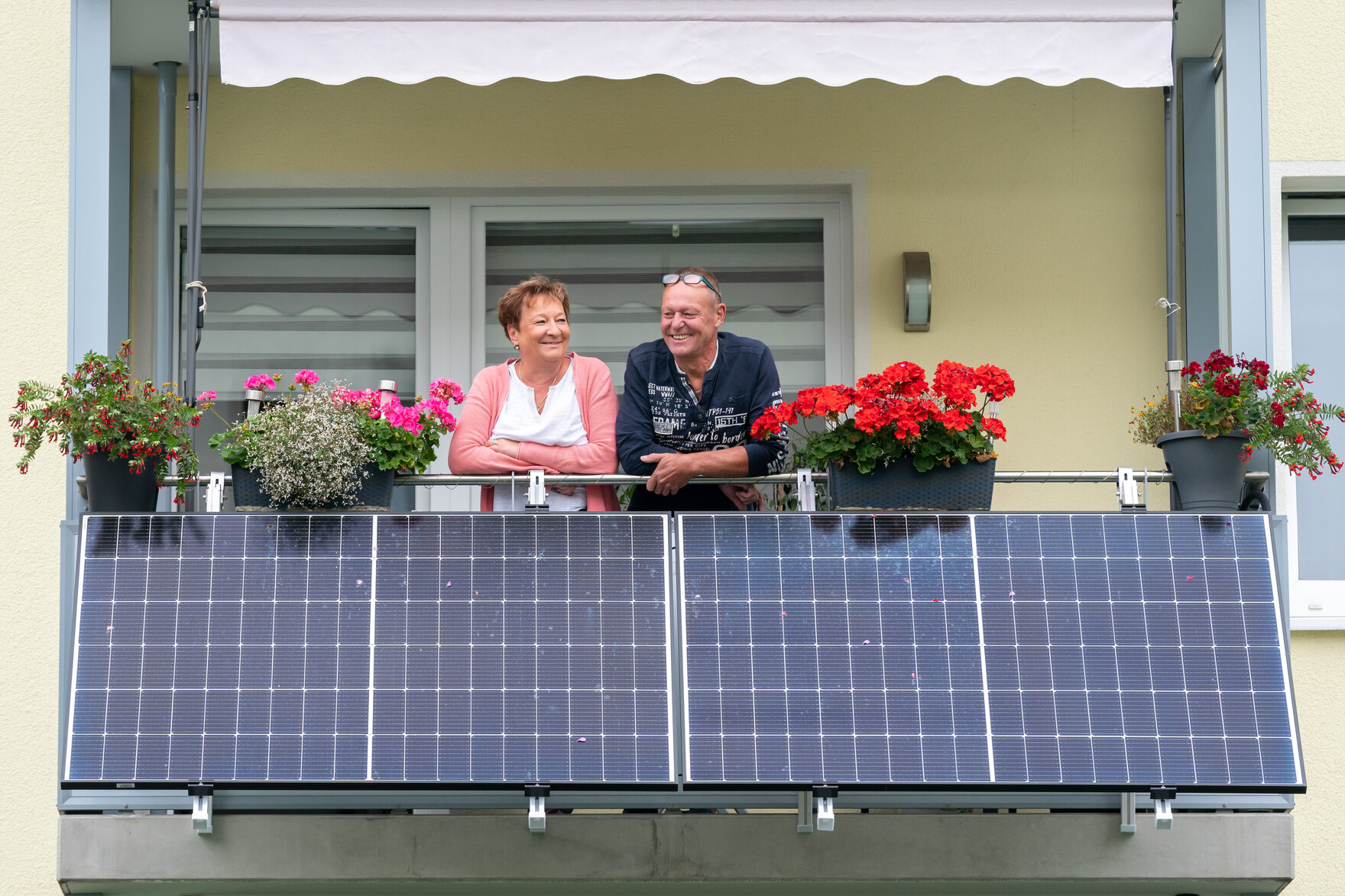 Förderrichtlinie Energie und Speicher, Symbolbild: Zwei Personen auf einem Balkon, davor ist ein Balkonkraftwerk installiert